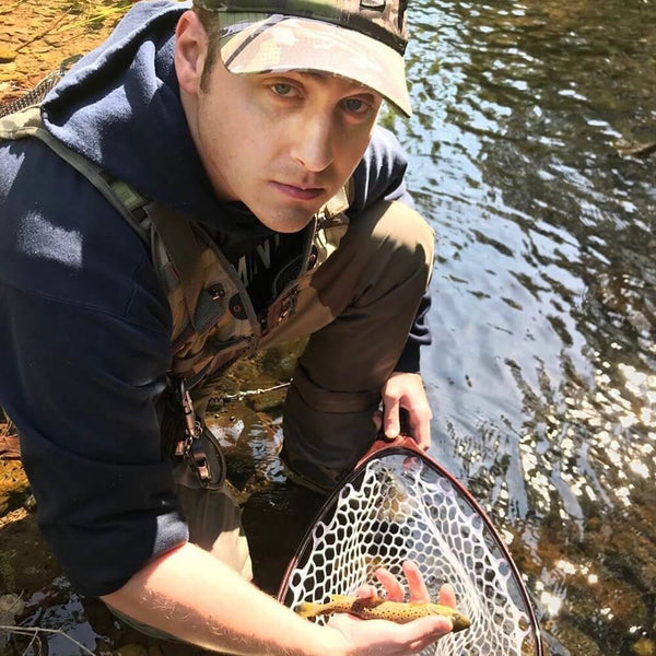 Fisherman holding smallspotted fish with fishing net