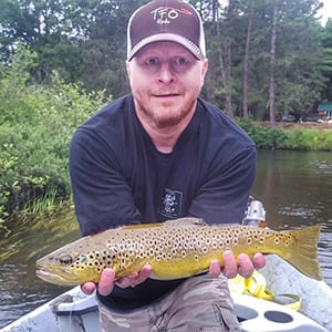 Man in a small boat holding his caught fish
