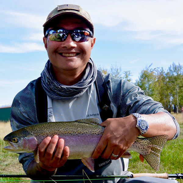 Fisherman holding green and purple fish